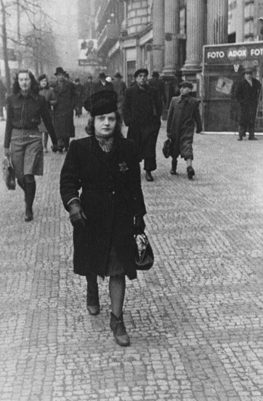 Elsa Eisner, marked with a Jewish badge, walks down a street in Prague. [LCID: 04570]