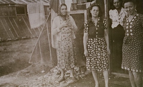 Women prisoners standing in front of barracks at the Gurs camp.