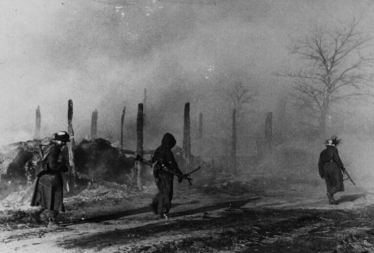 Des troupes allemandes passent à côté de bâtiments en ruine à Zhitomir. [LCID: 09605]