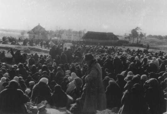 Over one thousand Jews from the Ukrainian town of Lubny, ordered to assemble for "resettlement," in an open field before they were massacred by Einsatzgruppen.
