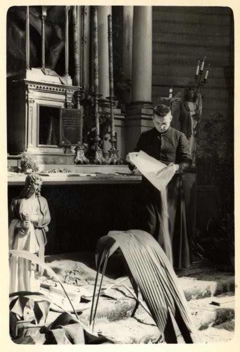 Father Wlodarczyk attempts to clean and repair a bombed-out church in the besieged city of Warsaw. Photographed by Julien Bryan circa 1939.