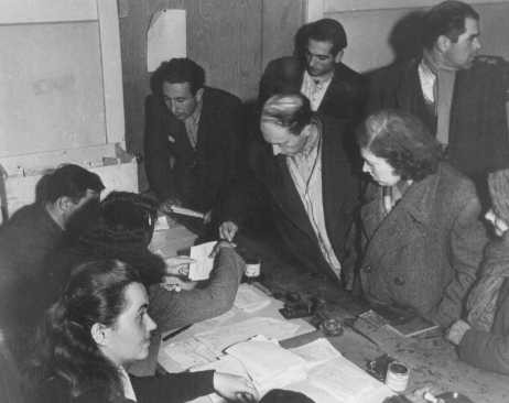 Checking identity cards of Jews who fled eastern Europe after the war (as part of the Brihah), in preparation for the journey to Palestine.