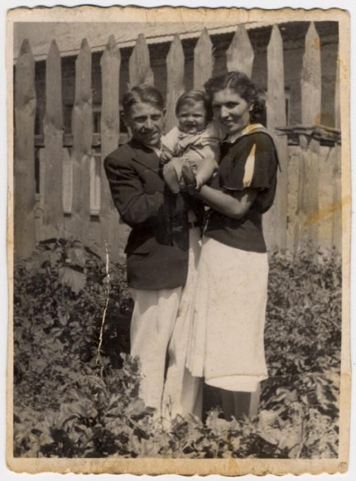 <p>Shlamke and Shanke Minuskin pose with their baby son, Henikel, in the garden of their home. Zhetel, Poland, 1938.</p>
<p> </p>