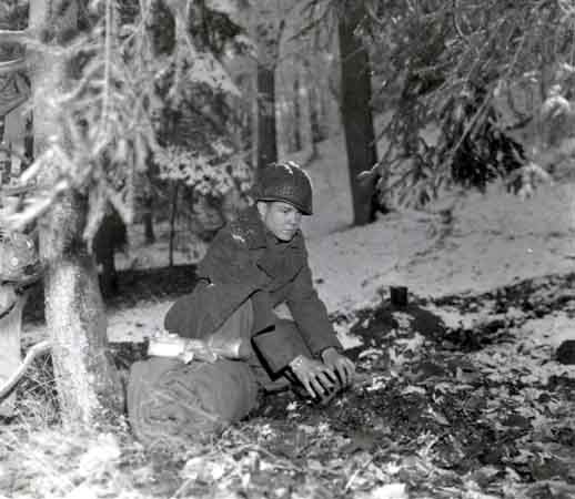 A soldier prepares to bed down for the night in a Belgian forest during the Battle of the Bulge.