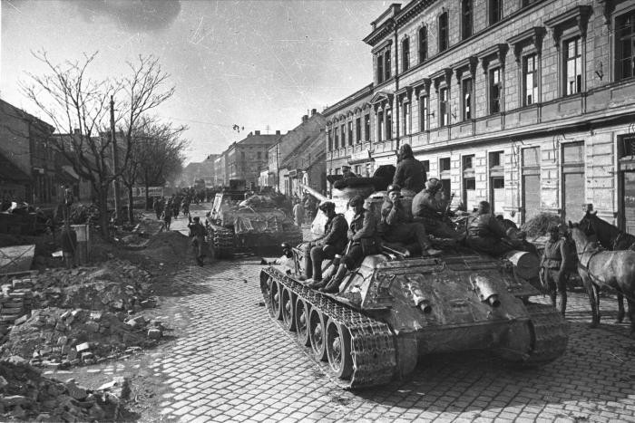 Soviet tanks roll down a street in Vienna