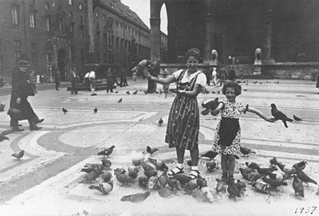 Berta and Inge Engelhard play with the pigeons in fron of the Feldherrenhalle in Munich.