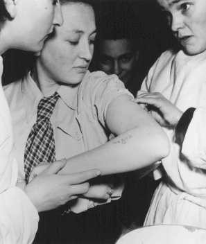 A former concentration camp prisoner receives care from a mobile medical unit of the United Nations Relief and Rehabilitation Administration.
