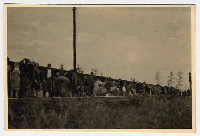 Displaced persons stand on a train platform in the weeks after the end of World War II in Europe. [LCID: 48905]