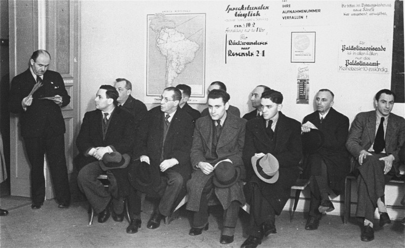 German Jews seeking to emigrate wait in the office of the Hilfsverein der Deutschen Juden (Relief Organization of German Jews). On the wall is a map of South America and a sign about emigration to Palestine. Berlin, Germany, 1935.
