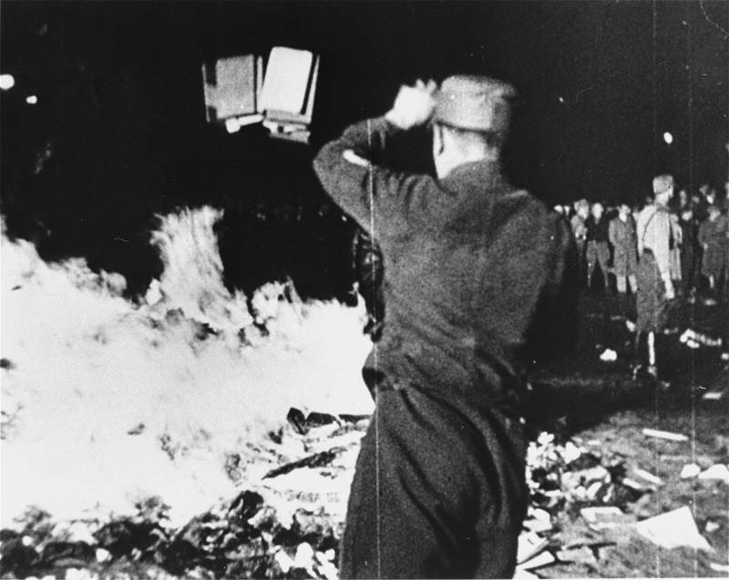 At Berlin's Opernplatz, an SA man throws books into the flames at the public burning of books deemed "un-German." [LCID: 01622]