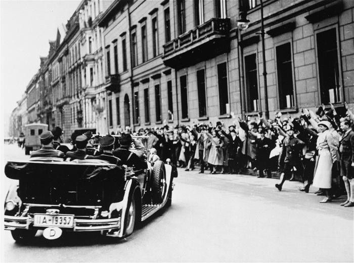 Cheering spectators greet Hitler upon his departure for the Reichstag session at which the Enabling Act was passed. The act allowed the government to issue laws without the consent of Germany’s parliament, laying the foundation for the complete Nazification of German society.
