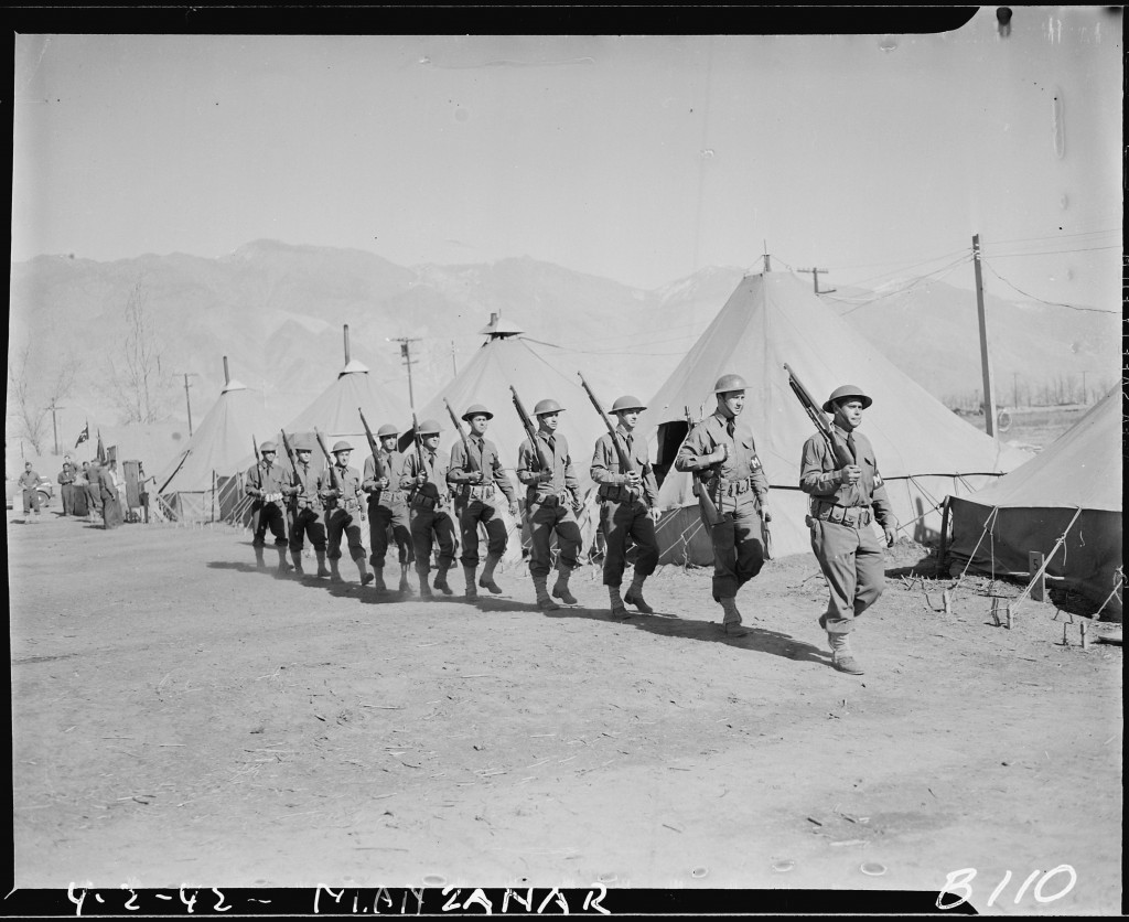 Army Military Police guarding the boundaries of the Manzanar Relocation Center in California, one of ten relocation camps where American residents of Japanese ancestry were forcibly deported, April 2, 1942.