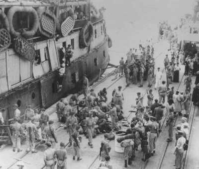 As UN official Emil Sandstroem (bottom right, white hat) looks on, British soldiers remove Jewish refugees from the ship "Exodus ... [LCID: 69913]