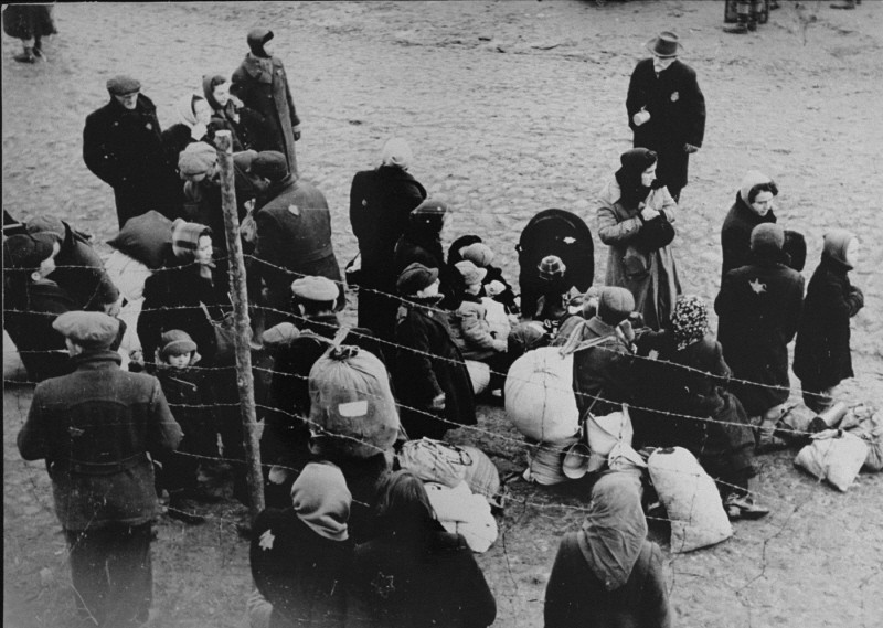 Jewish families with bundles of belongings during deportation from the Kovno ghetto to Riga in neighboring Latvia.
