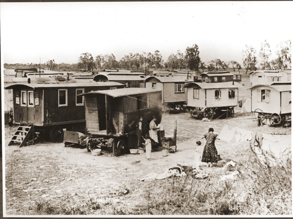 Romani (Gypsy) women boil laundry and hang it to dry in the middle of the caravan camp at Marzahn. [LCID: 82685]