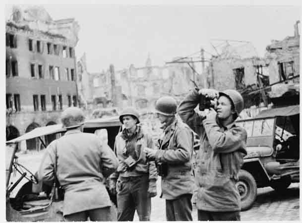 US Army Signal Corps photographers from Combat Unit 123 photograph ruins in the city of Naumburg, Germany.