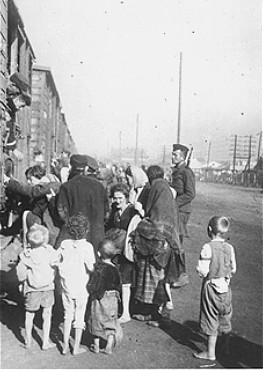 Under guard, Jewish men, women, and children board trains during deportation from Siedlce to the Treblinka killing center.