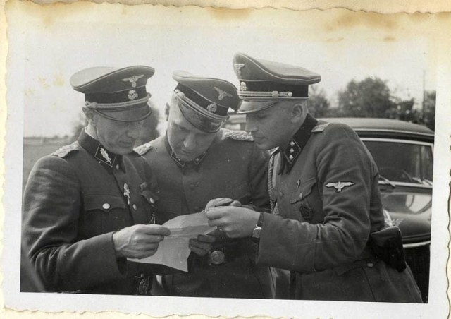 Richard Baer and Karl Höcker look over a document with SS-Standartenführer Dr.