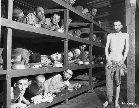 Former prisoners of the "little camp" in Buchenwald stare out from the wooden bunks in which they slept three to a "bed."