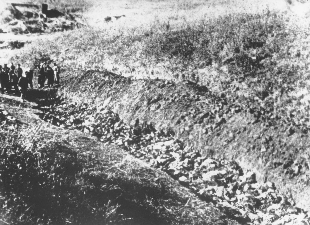 Soviet investigators (at left) view an opened grave at Babi Yar. [LCID: 5056x]