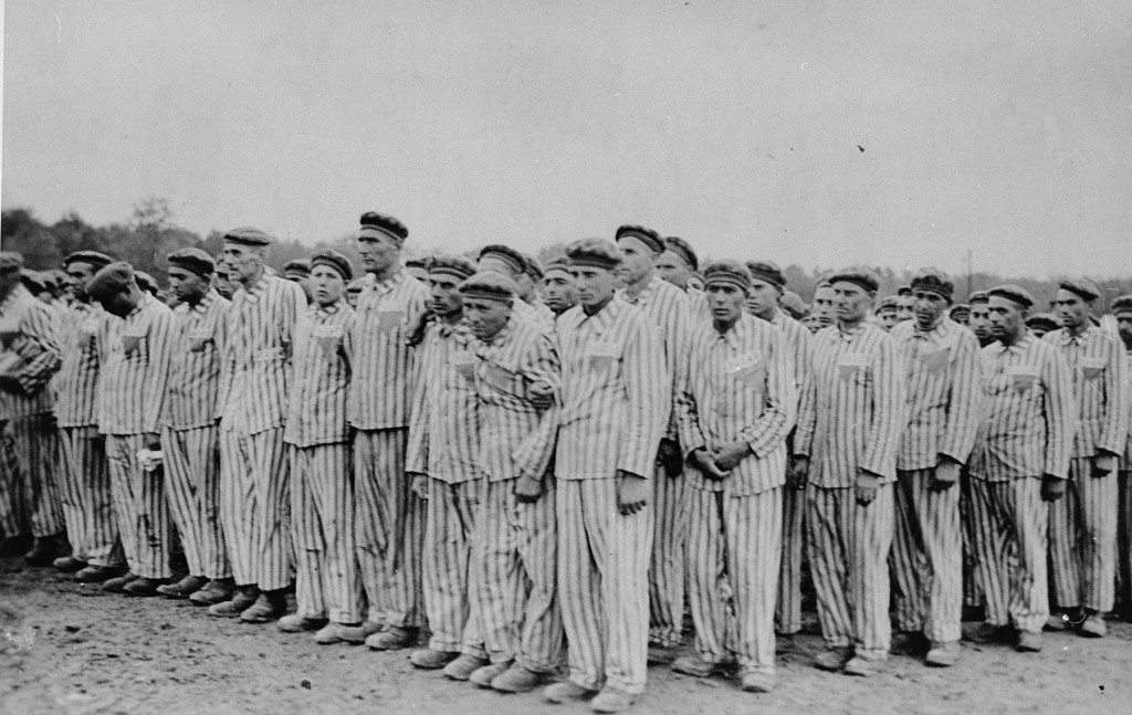 Prisoners during a roll call at the Buchenwald concentration camp. Their uniforms bear classifying triangular badges and identification numbers. Buchenwald, Germany, 1938–41.