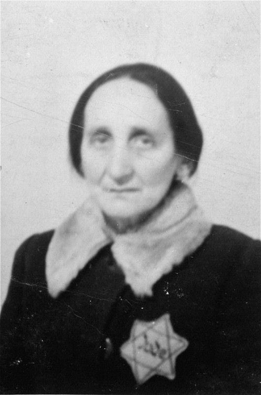Portrait of an elderly Jewish woman wearing a Jewish badge in the Olkusz ghetto.