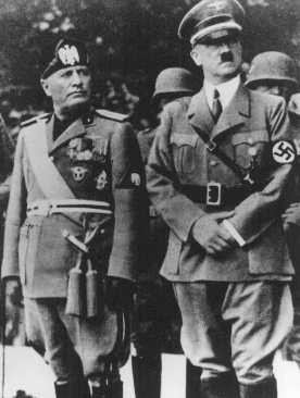 Benito Mussolini and Adolf Hitler stand together on an reviewing stand during a official visit to occupied Yugoslavia, 1941-1943. [LCID: 89908]