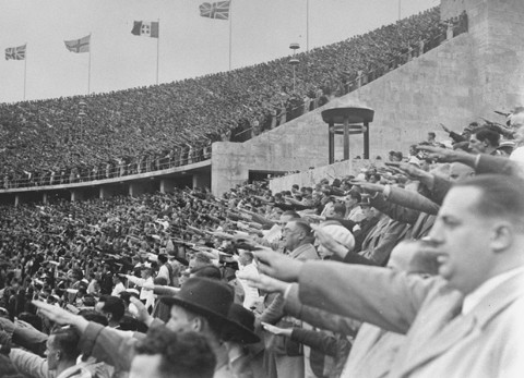 In the Olympic Stadium, German spectators salute Adolf Hitler during the Games of the 11th Olympiad.