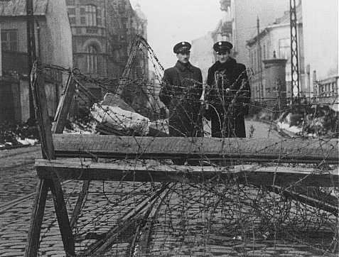 Jewish police at a barricaded entrance to the Warsaw ghetto.