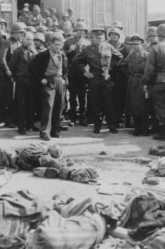General Dwight D. Eisenhower (center, right) views the corpses of victims of the Ohrdruf camp. [LCID: 23005a]