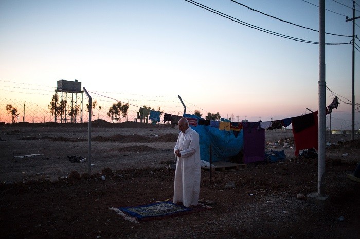 A Sunni man from Mosul, Iraq, prays as the sun sets over an internally displaced persons (IDP) camp near Erbil, Iraqi Kurdistan. [LCID: ref04]