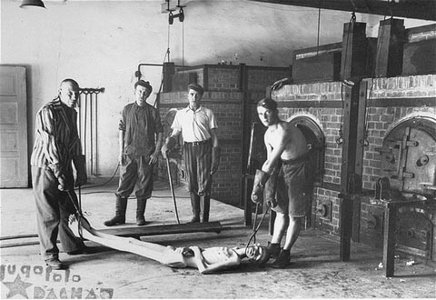 Survivors of the Dachau concentration camp demonstrate the operation of the crematorium by preparing a corpse to be placed into one ... [LCID: 15028]