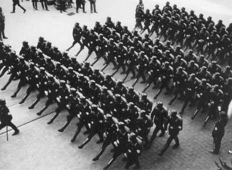 Members of the SS (Schutzstaffel; originally Hitler's bodyguard, later the elite guard of the Nazi state) parade during a rally. [LCID: 86520]