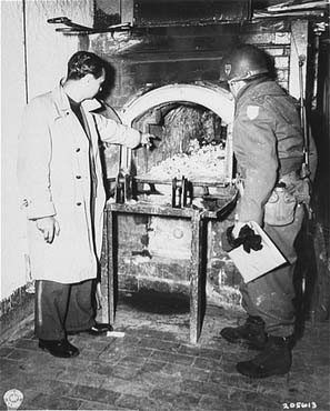 After the liberation of the Flossenbürg camp, a US Army officer (right) examines a crematorium oven in which Flossenbürg camp victims were cremated.