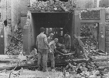 Concentration camp prisoners, many from satellite camps of Neuengamme, remove corpses of German civilians after Allied bombings of Hamburg.