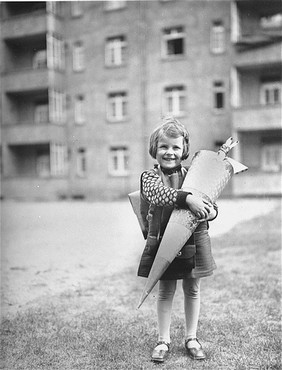 Berta Rosenheim poses with a large cone, traditionally filled with sweets and stationery, on her first day of school. [LCID: 12479]
