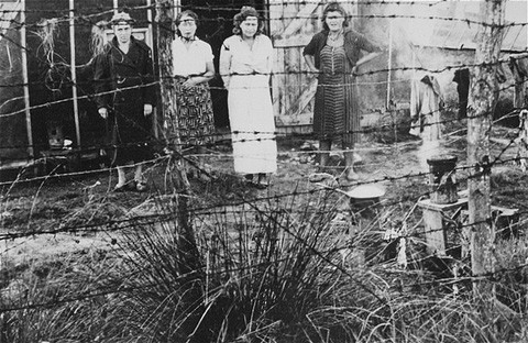 Jewish women prisoners behind a barbed-wire fence at the Gurs detention camp.