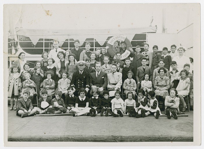 <p>Gilbert and Eleanor Kraus (seated in the center, next to the ship's captain) pose with the 50 Austrian Jewish children they brought to the <a href="/narrative/3486">United States</a>. Photograph taken in June 1939.</p>
<p>All the children rescued by the Krauses were from families that had previously tried to escape Nazi territory. After the children arrived in the United States, they were sent to live with foster families until their parents were able to <a href="/narrative/12009">immigrate</a>. However, many were never reunited with their families.</p>