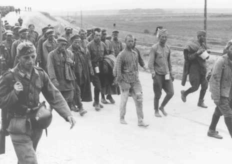 German soldiers guard Soviet prisoners of war marching to camps. [LCID: 91085]