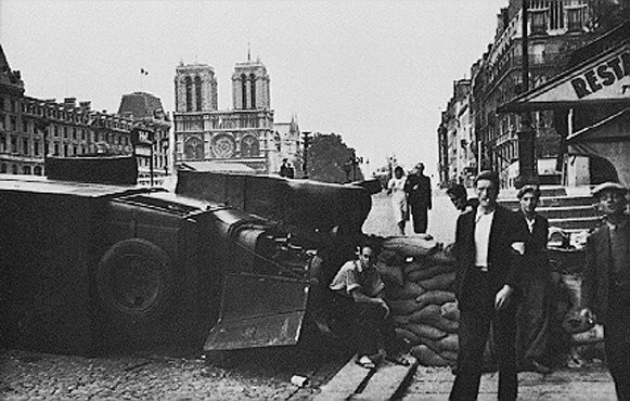 During the battle to liberate the French capital, a barricade is hastily built near the cathedral of Notre Dame. [LCID: paris2]