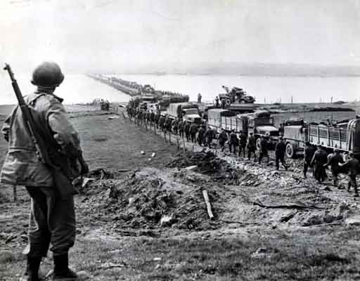 German prisoners file across the Rhine as American supply trucks move forward toward the front. [LCID: sc255]