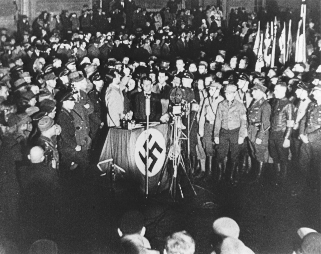 Propaganda Minister Joseph Goebbels (at podium) praises students and members of the SA for their efforts to destroy books deemed "un-German" during the book burning at Berlin's Opernplatz.