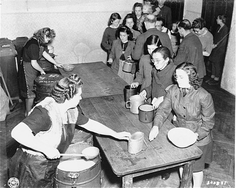 Hot food is served at the displaced persons camp on Arzbergerstrasse. [LCID: 81587]