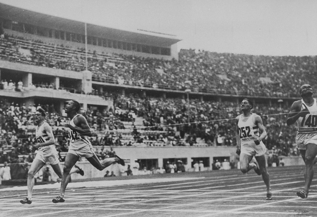 American runner Archie Williams (2nd from left) breaks the tape at the finish line of the 400m event at the Olympic games in Berlin. Williams won the race in a record time of 46.5 seconds.