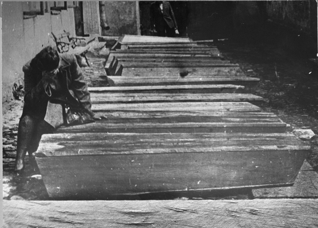 A woman mourns by the coffins of Jews who died in the Kielce pogrom. [LCID: 63688a]
