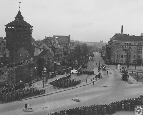 The inhabitants of Nuremberg watch a parade of US troops through their city. [LCID: 34618]