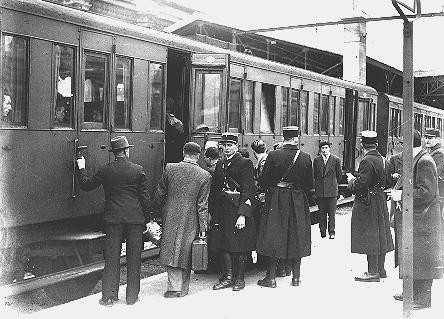 Jewish deportees, guarded by French police, board a train at the Austerlitz station for transport to the Pithiviers internment camp. [LCID: 44279]