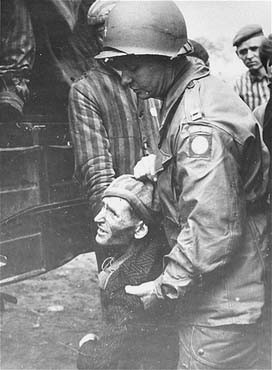 A chaplain with the 82nd Airborne Division helps a survivor board a truck that will evacuate him from the Wöbbelin concentration camp to an American field hospital.