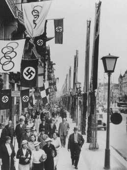 A street scene showing displays of the Olympic and German (swastika) flags in Berlin, site of the summer Olympic Games. [LCID: 76499]