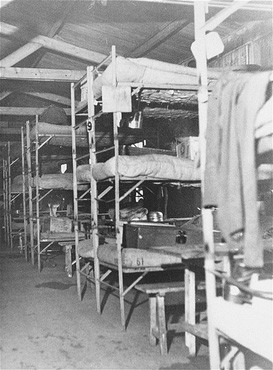 The interior of a barracks at the Westerbork transit camp, after liberation. [LCID: 41174]